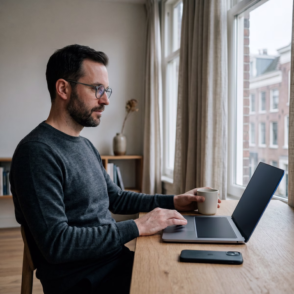 Man working calmly at a laptop in a modern European home office